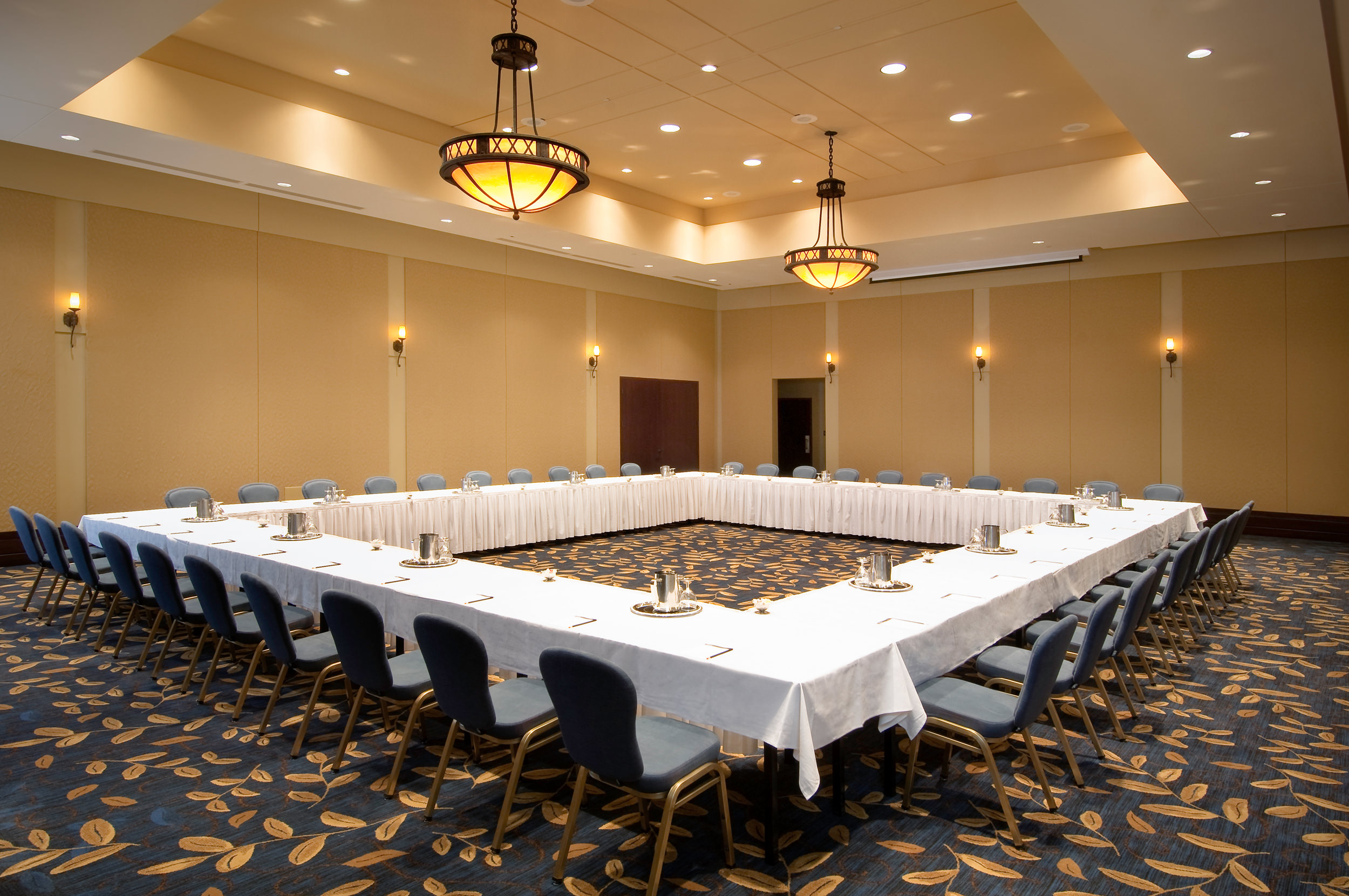 meeting room set up with long tables in the shape of a large square