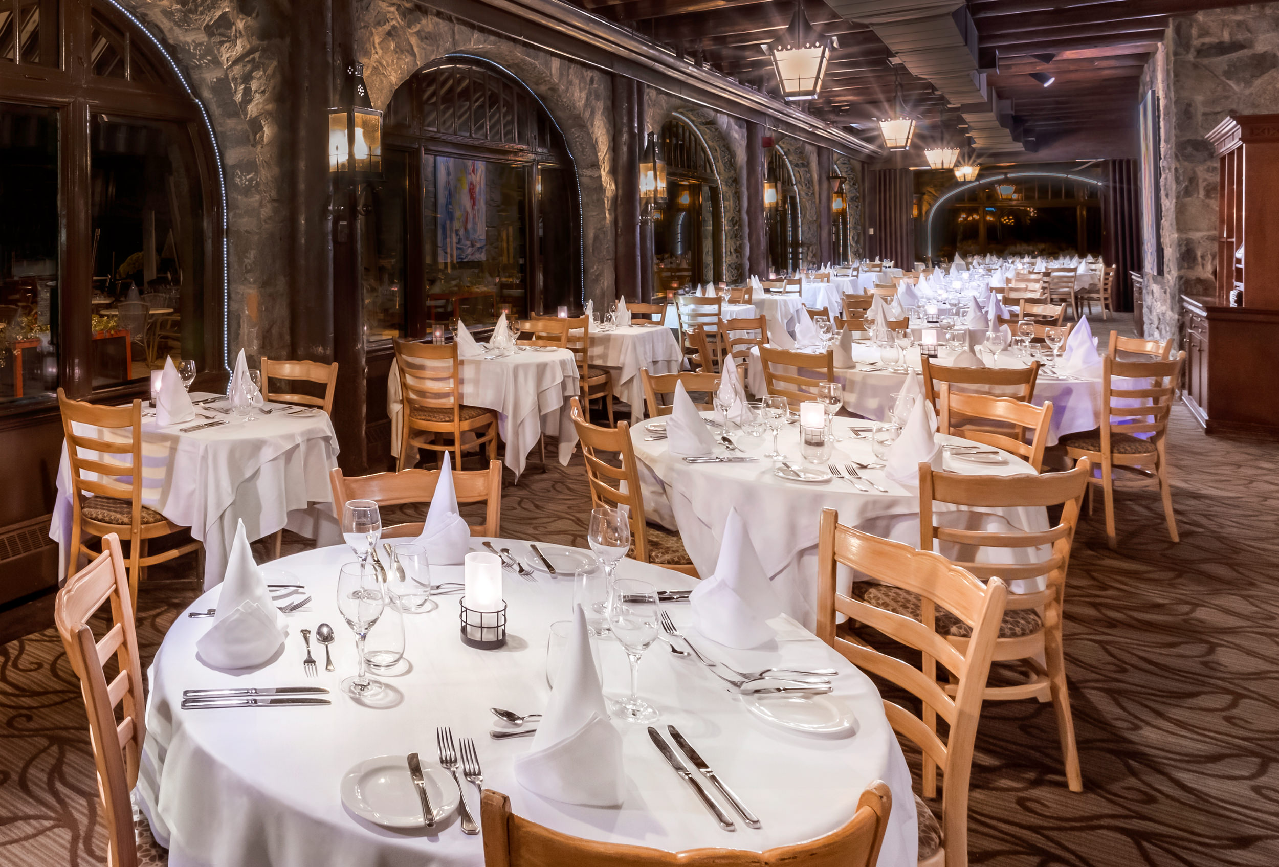 tables set up for an event in a long stone room