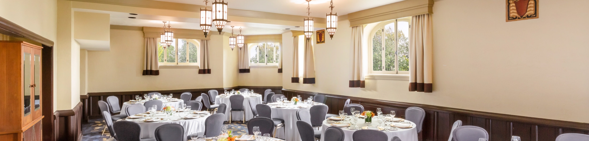 Une chambre avec des tables rondes installées pour un mariage