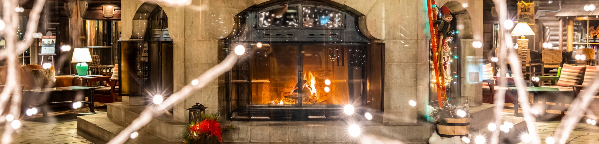 view of festively decorated fireplace through a few branches