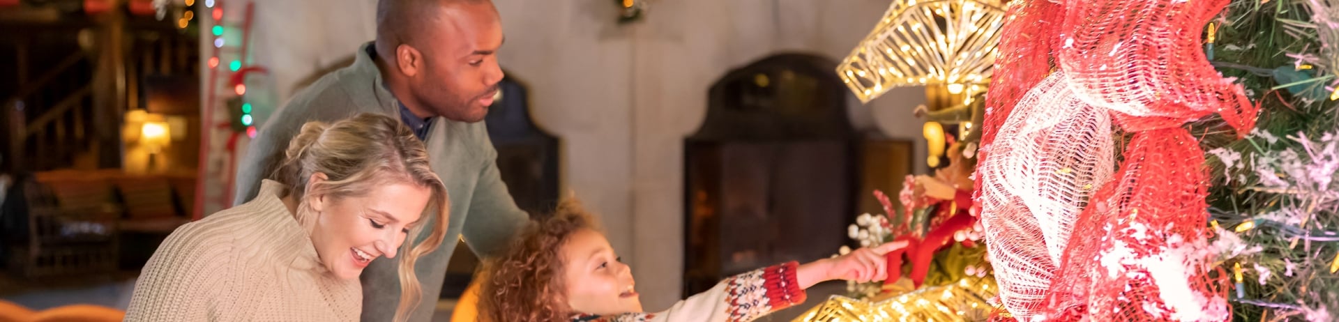 Famille qui regarde le grand arbre de Noël dans le hall