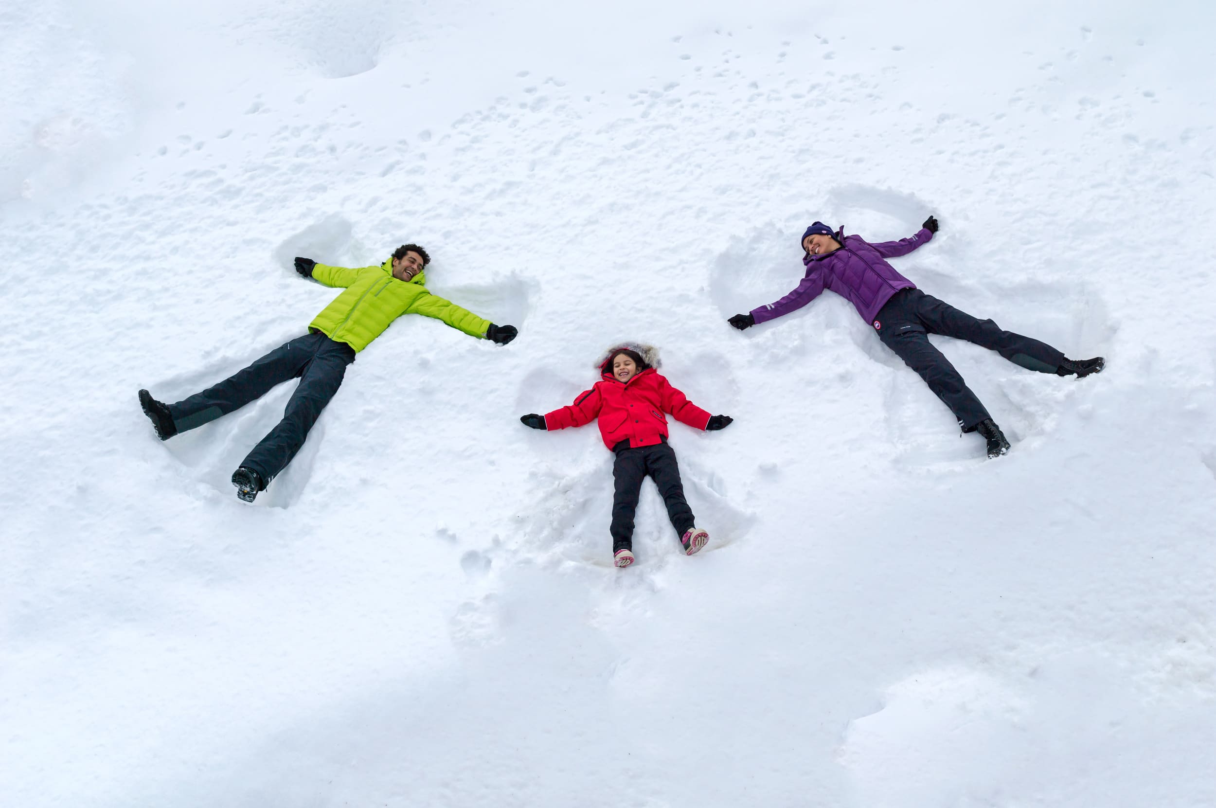 family making snow angels