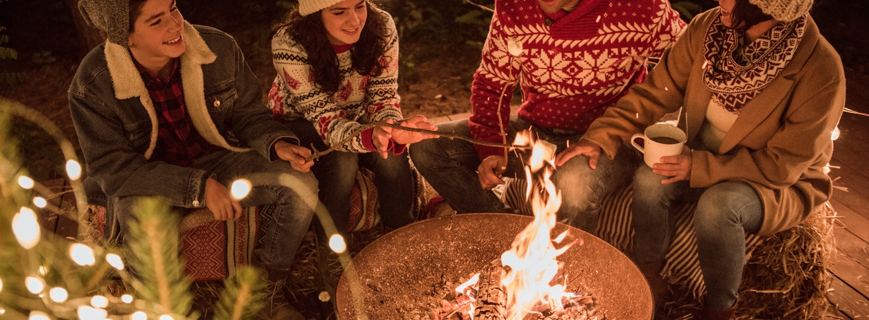 wood firepit group of friends wearing sweaters chateau montebello