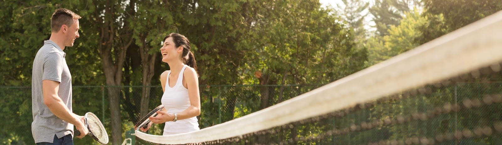 two people talking at the tennis net
